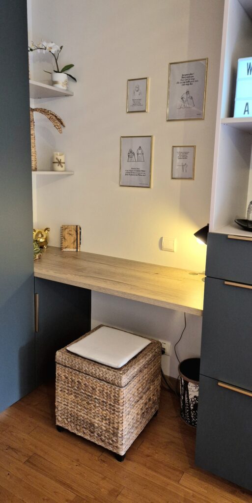 Bureau suspendu en bois avec lampe de lecture, tabouret en osier et décorations encadrées au mur