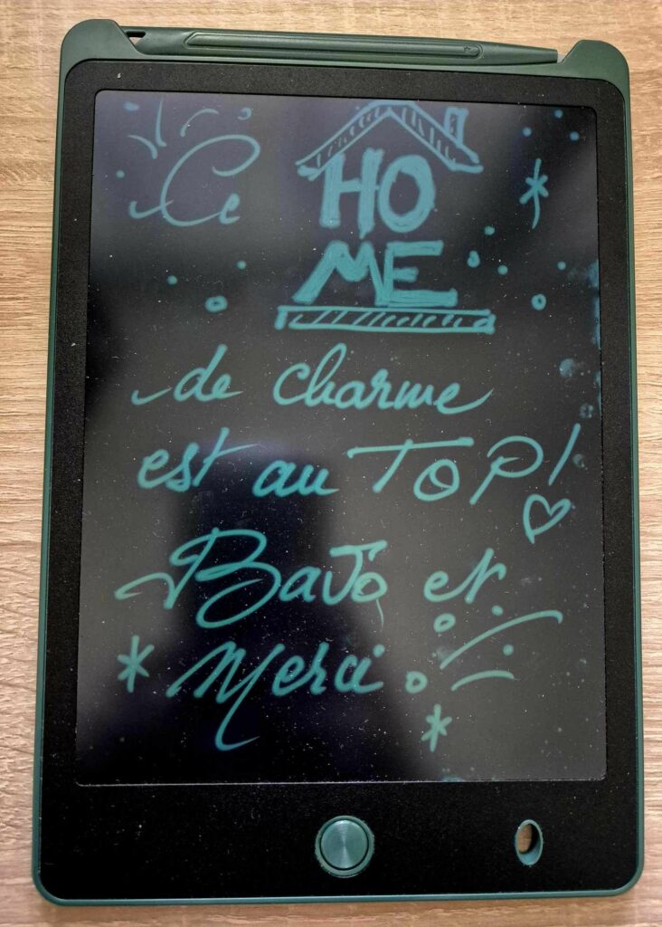 Tablette numérique affichant un message de satisfaction client "Ce home de charme est au top! Bravo et merci"